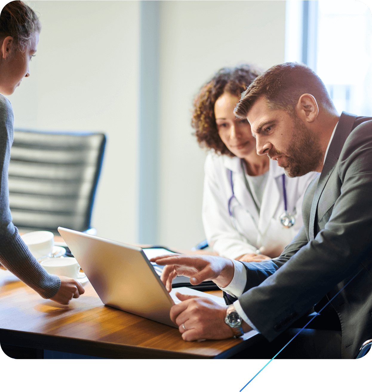 Three pharmaceutical business and medical leaders reviewing information on a laptop together
